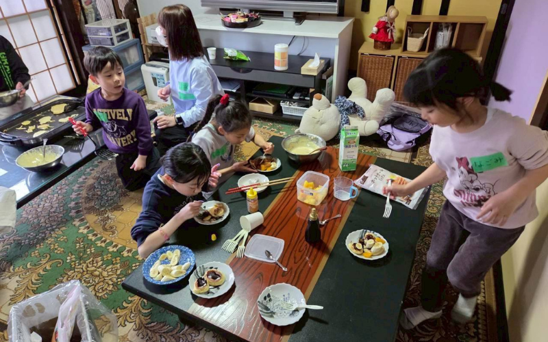 拠点でごはんを囲む子どもと大人