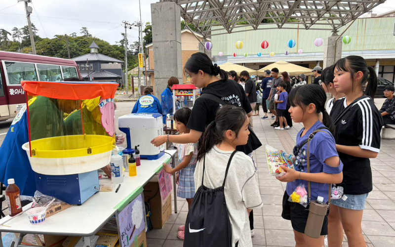 イベントの出店を手伝うボランティアと子どもたち