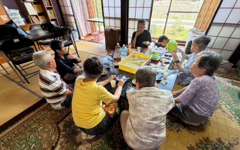 高齢の方と子どもたちが一緒に食卓を囲む様子